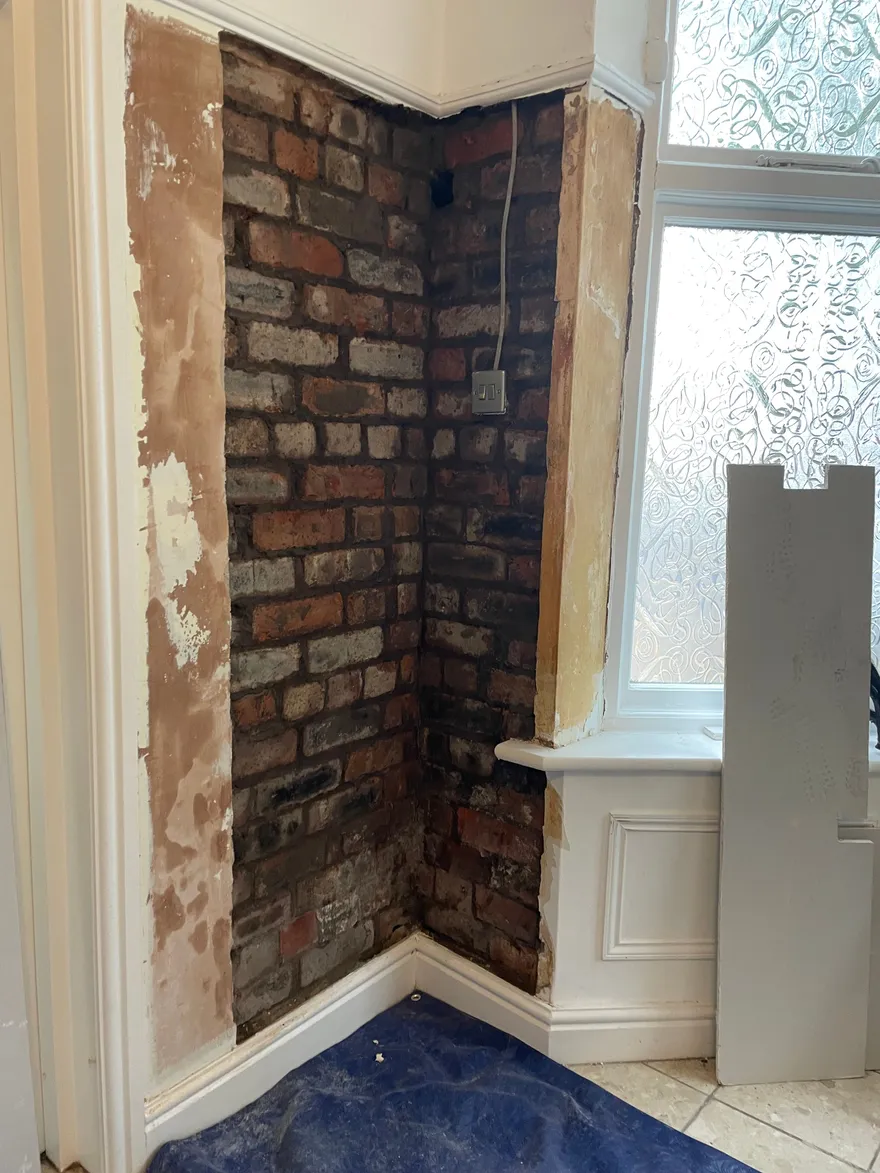 The same wall stripped back to bare brickwork.