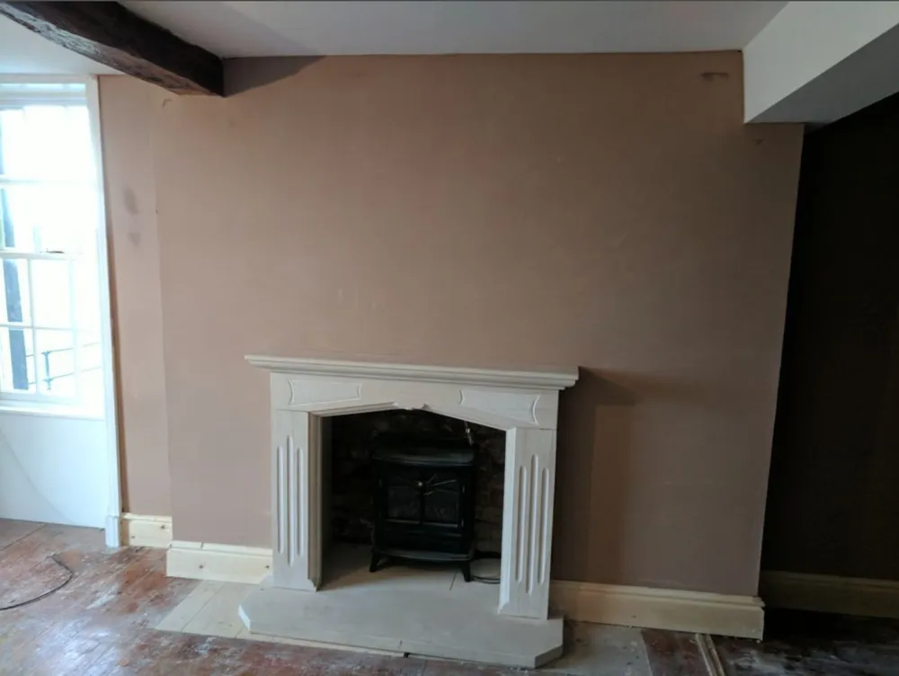 A front room replastered around a leaded window.