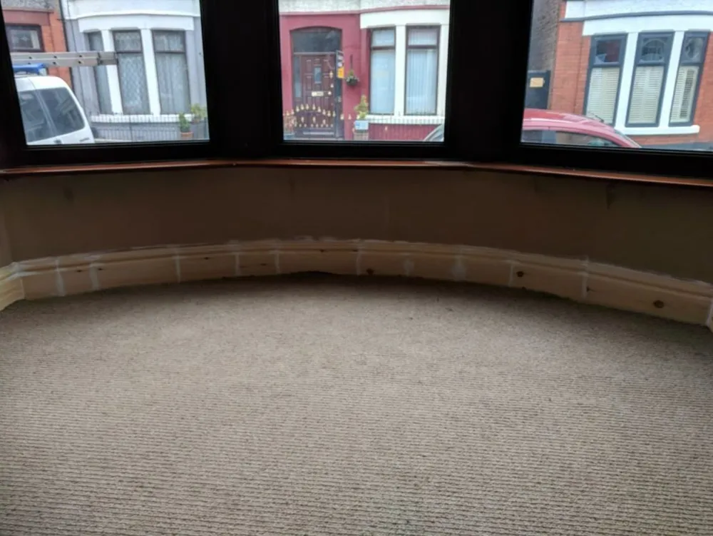 A wall replastered up to the existing dado rail.